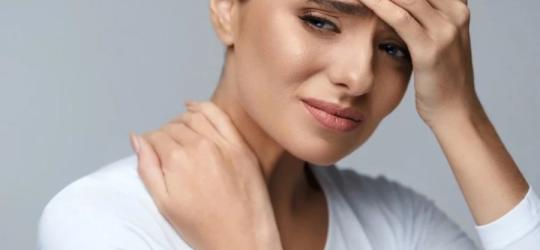 Kobieta zmaga się z silnym bólem głowy.